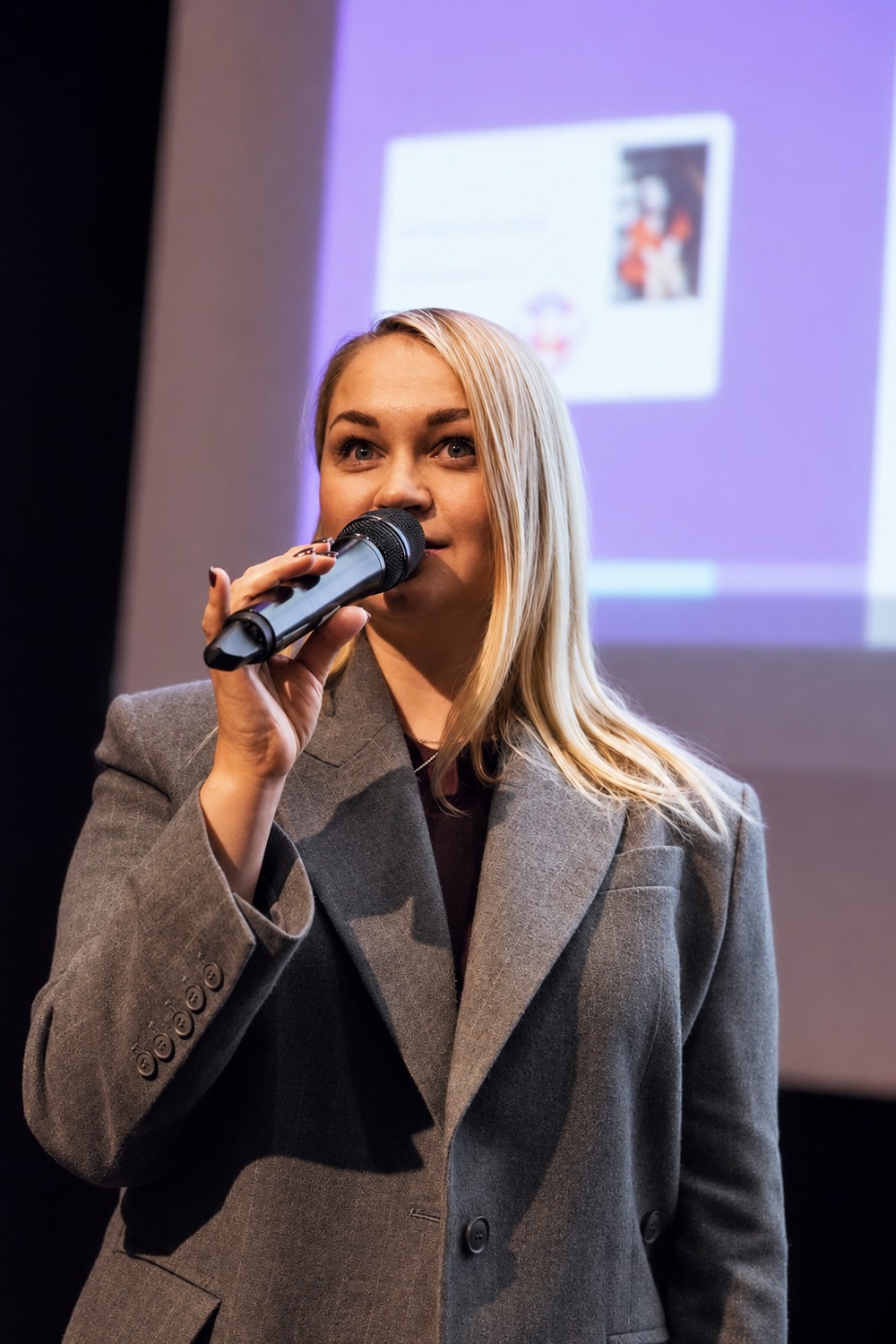 Виступ на події Nordic Club UA: спікерка з мікрофоном перед екраном презентації